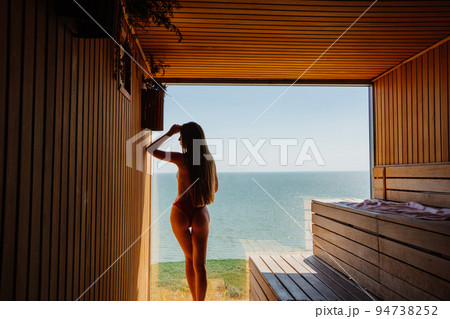 a slender,beautiful woman topless by the panoramic window in the sauna a slender,beautiful woman topless by the panoramic window in the sauna 94738252