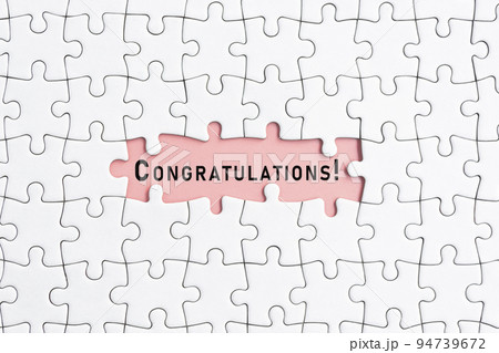 White jigsaw puzzle with congratulations word over pink background. White jigsaw puzzle with congratulations word over pink background. 94739672