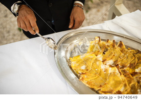 Man putting food on a plate at a wedding party 94740649