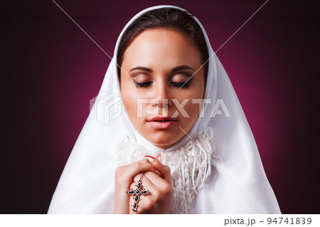 Nice girl dressed as a nun on a black background Nice girl dressed as a nun on a black background 94741839