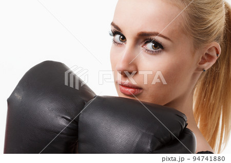 Isolated portrait of athletic Asian woman in black boxing gloves. Slim athletic girl in training clothes looking at camera. Vertical concept photo of sport, boxing, victory, rivalry theme 94741880