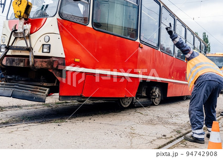 Crane and workers are lining up a derailed tram. Crane and workers are lining up a derailed tram. 94742908