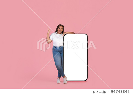 African American Female Near Big Smartphone Screen Over Pink Background African American Female Near Big Smartphone Screen Over Pink Background 94743842