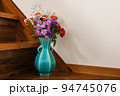 階段に置かれた様々な花を活けた青色の花瓶 94745076