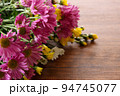 木材背景の菊の花束 94745077