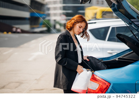 A woman puts things in the car A woman puts things in the car 94745322