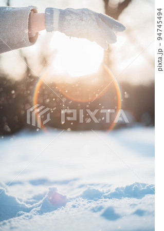 逆光の中、雪を掴む女性 逆光の中、雪を掴む女性 94745494