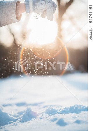 逆光の中、雪を掴む女性 逆光の中、雪を掴む女性 94745495