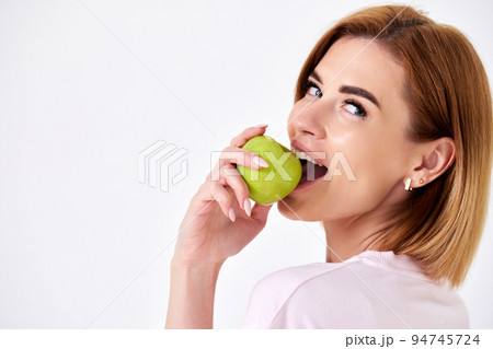 girl holding green apple isolated on white background 94745724