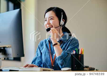 オフィスで電話対応をする若い女性 94746599