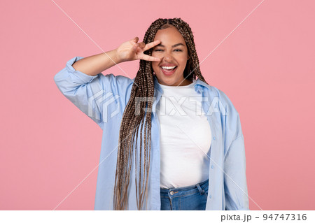 Joyful Black Woman Having Fun Posing Gesturing V-Sign, Pink Background 94747316