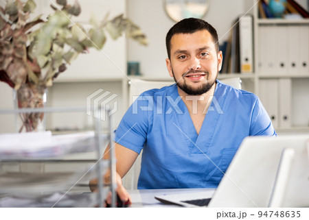 Portrait of male doctor using laptop in office Portrait of male doctor using laptop in office 94748635