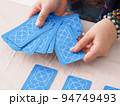 タロット占いでカードを選ぶアジア人女性 94749493