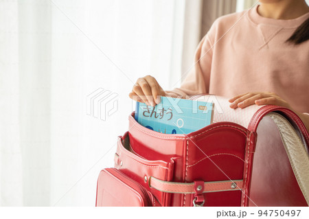 ランドセルから算数ノートを取り出す小学生 94750497