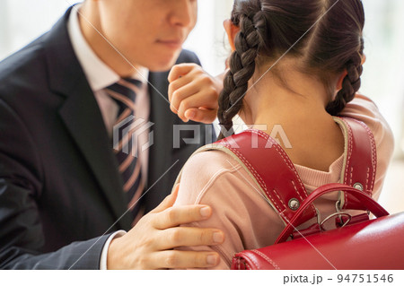 泣いている小学生を慰める男性 94751546