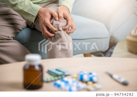 Asian senior man retirement knee joint pain on sofa 94754292