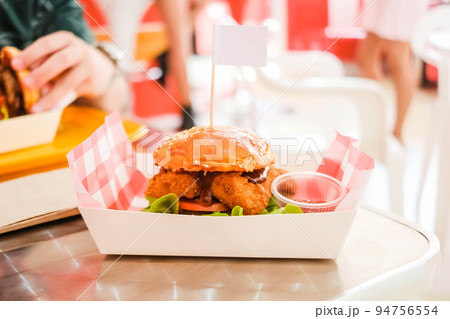 A fish burger with a blurred background. 94756554