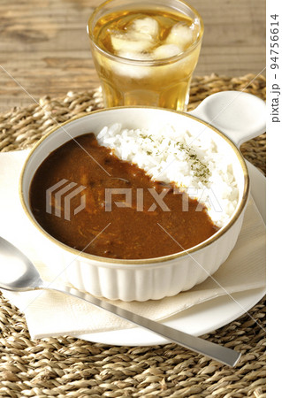 耐熱皿に盛られたチーズカレーライスとお茶 94756614