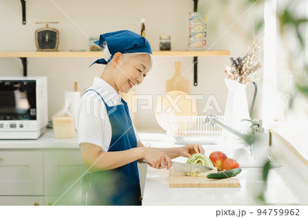 キッチンで料理をするハウスキーパーのシニア女性 94759962