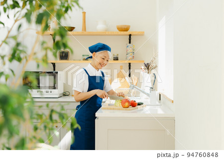 キッチンで料理をするハウスキーパーのシニア女性 94760848
