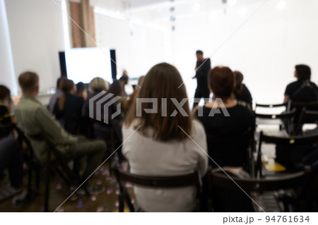 Blurred background of the business conference, one man on the stage, presentation of the project, public talk. High quality photo 94761634