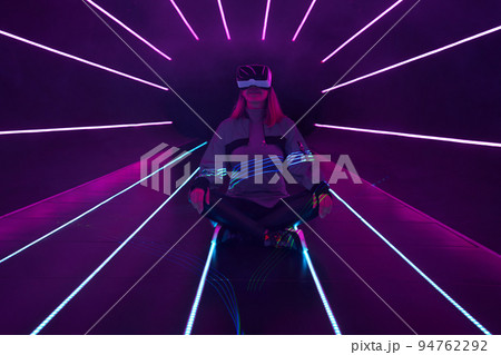 Woman is using virtual reality headset to access in metaverse. 94762292