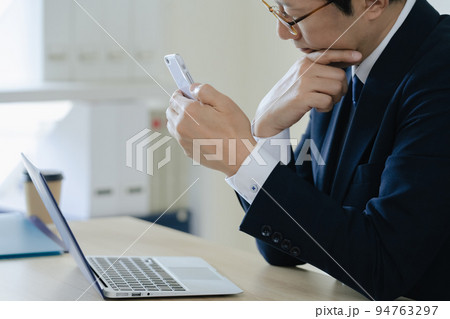 ノートパソコンを見て悩むビジネスマン 94763297