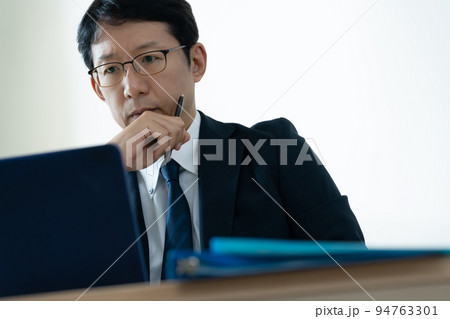 ノートパソコンを見て悩むビジネスマン ノートパソコンを見て悩むビジネスマン 94763301