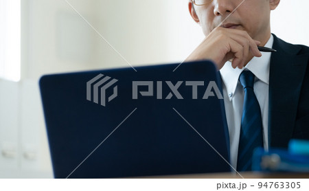 ノートパソコンを見て悩むビジネスマン ノートパソコンを見て悩むビジネスマン 94763305