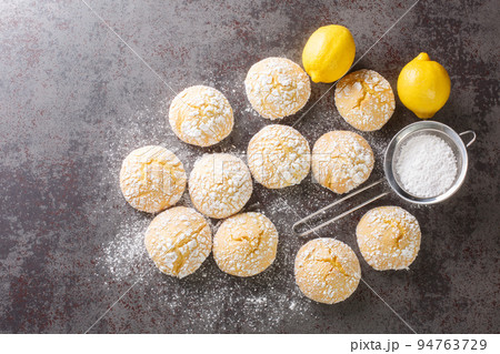 Close-up of cracked lemon biscuits sprinkled with powdered sugar close-up. horizontal top view Close-up of cracked lemon biscuits sprinkled with powdered sugar close-up. horizontal top view 94763729