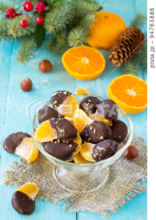 Slices of Tangerines in Chocolate. Dessert Tangerines on a wooden table. Slices of Tangerines in Chocolate. Dessert Tangerines on a wooden table. 94763886