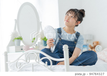 ベッドの上であぐらをかいて鏡を見る女子高生 ベッドの上であぐらをかいて鏡を見る女子高生 94764327