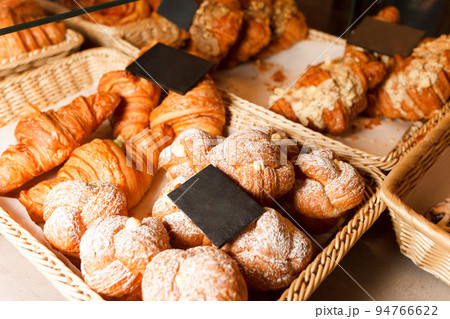 Delicious freshly baked pastries in a pastry shop. Many buns and croissants on a shelf of a baking shop. Delicious freshly baked pastries in a pastry shop. Many buns and croissants on a shelf of a baking shop. 94766622