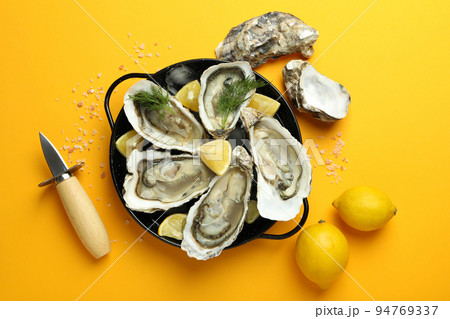 Concept of delicious seafood, oysters on orange background 94769337