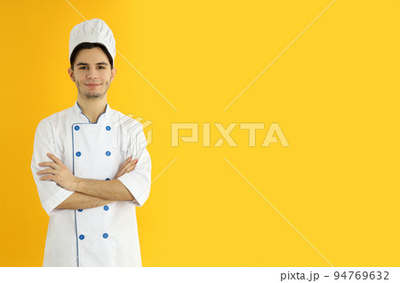 Concept of cooking, young man chef on yellow background 94769632