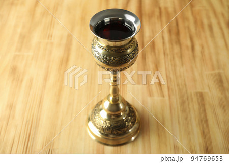 Concept of Eucharist with goblet of wine on wooden background 94769653