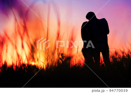 silhouette of a young couple kissing at sunset 94770039