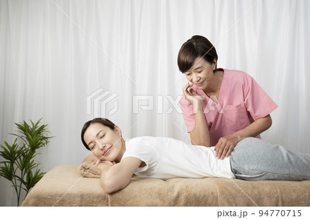 背中のマッサージをする整体師 94770715