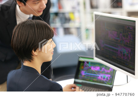 先輩とCAD画面を見ながら設計する女性設計者_1 94770760