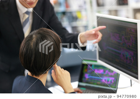 先輩からCAD操作のレクチャーを受ける女性設計者_4 94770980