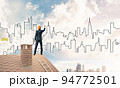 Man architect draw silhouette of modern city on blue sky. Mixed 94772501