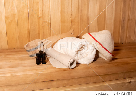 Traditional old Russian bathhouse SPA Concept. Interior details Finnish sauna steam room with traditional sauna accessories set basin towel aroma oil scoop felt. Relax country village bath concept 94772784