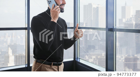 businessman gives a thumbs up. A person uses mobile technologies 94773377