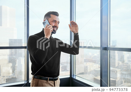 smiling business man talking on his smartphone. 94773378