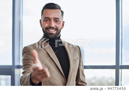 smiling businessman offering you his handshake. close-up. 94773450