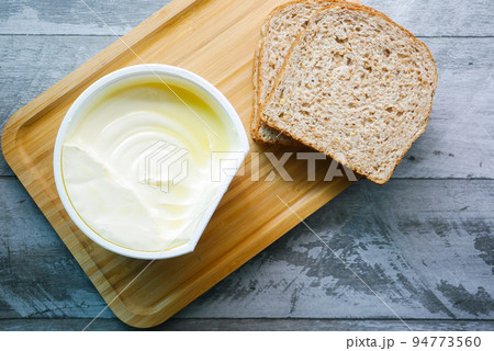 fresh butter in a container with bread on white background fresh butter in a container with bread on white background 94773560