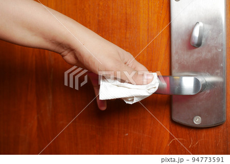 cleaning door knob with tissue close up cleaning door knob with tissue close up 94773591