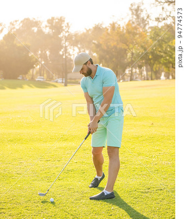 playing golfer in cap with golf club, recreation 94774573