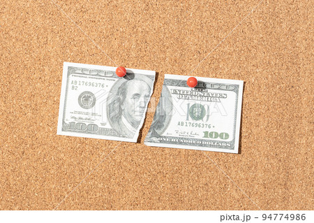 Fake Ripped dollar banknote pinned on cork board 94774986