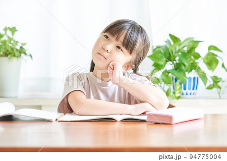 家で勉強をしながら考える女の子 94775004